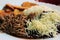 Venezuelan typical dish called Pabellon, made up of shredded meat, black beans, rice, fried plantain slices, and salty cheese.