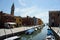 Venice canal with boats and colorful houses and church on Burano island,