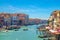 Venice cityscape with Grand Canal waterway. View from Rialto Bridge. Gondolas, boats, vaporettos docked and sailing Canal Grande