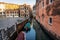 Venice cityscape with narrow canal, moored boats and ancients colorful buildings, Italy