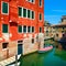 Venice cityscape, water canal, boats and traditional buildings.