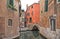 Venice colorful corner with old buildings, small water canal, little bridge and boats