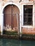 Venice door and barred window along canal