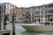 Venice, a girl in a dress stands on a bridge near the water. Wind develops hair