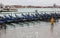 Venice at high tide and mooring gondolas with a person in yellow raincoat and rubber boots