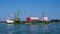 Venice, Italy - 07 May 2018: Self-propelled barge carrying an excavator and a tanker truck across the Venetian lagoon