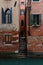 VENICE, ITALY February 16 , 2020.Picturesque Venice`s red buildings with green windows near at canal