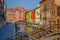 VENICE, ITALY - JUNE 18, 2015: Water canal with beautiful wooden bridge, colored houses around