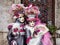 Venice, Italy - March 1, 2019 Two person dressed with typical Venice Costumes pose for a photo