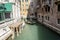 Venice, Italy - March 11, 2012: Typical Gondola with gondolier rowing along a narrow canal in Venice