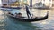 VENICE, Italy - May 2019: elderly gondolier carries an elderly couple in a gondola along the Grand Canal. Maneuvers with