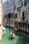 VENICE, ITALY - May 23, 2016: Gondolier with passengers on gondola taking trip through beautiful and colorful Venice. Venice build