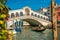 VENICE, ITALY - October 02, 2017: Gondola cruises pass through Rialto bridge in Venice, Italy