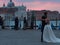 VENICE, ITALY - OCTOBER 8 , 2017: bride and groom hugging on Piazza San Marco, gondolas on the background