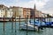 Venice, Italy. Parked motor boat and gondolas near wooden posts