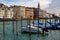 Venice, Italy. Parked motor boat and gondolas near wooden posts