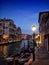 Venice at night with lamplight reflected in the water boats and