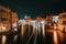 Venice night scenery. Light illuminated trails of ferries and boats reflected on the Grand Canal surface. Majestic