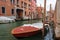 Venice street canal with boat near living buildings, Italy. Venice narrow channel landscape