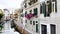 Venice street with narrow canal between houses with parked boats