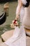 Venice wedding in Italy. A bride in a white dress, with a train, with a bouquet of white and red roses in her hands