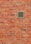 Vent on Weathered Brown Brick Wall, Vertical Pattern