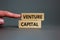 Venture capital symbol. Wooden blocks with words Venture capital on beautiful grey background, copy space. Businessman hand.