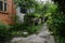 Verdant path outside aged red-brick dwelling building