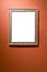 Verical silver picture frame on red brown wall