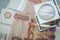 Verification of Russian banknotes for authenticity under a magnifying glass. Used money. Selective focus