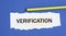 VERIFICATION - word on a torn white paper on a blue background