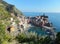 Vernazza on a bright sunny day as seen from the path leading from Monterosso. Cinque Terre, Liguria, Italy