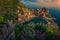 Vernazza view with harbor and mediterranean plants at sunset, Italy