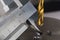 Vernier caliper measures metal drill bit, make holes in steel billet on industrial drilling machine. Metal work industry