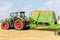 The versatile seed drill is mounted on a tractor against the backdrop of a harvested agricultural field