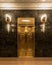 Vertical 4x5 elevator in vintage art deco building with marble walls and golden sconces