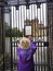 Vertical of an adult woman reading about Queen's death on the gates of Palace of Holyroodhouse