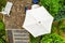 Vertical aerial photograph of a bright parasol on a terrace, taken from close up with the drone.