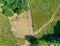 Vertical aerial photograph of an unmaintained dry meadow on a dirt road, where the lanes lead into the road