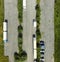 Vertical aerial view of an almost empty asphalted grey parking lot with two trucks and cars