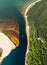 Vertical aerial view of a speedboat sailing along the river on the shore of golden sand