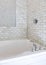 Vertical Alcove bathtub with marble subway tile surround and shower head