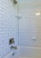 Vertical Alcove bathtub with white subway tile surround with black grout
