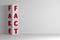 Vertical arrangement of four white cubes and red words FAKE and FACT