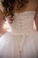 Vertical back view of a bride in a dress with a corset back