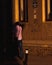 Vertical back view of a man walking in the street in front of building during sunset