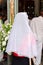 Vertical back view of a woman praying at a religious ceremony in a church with a white veil, Brazil
