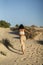 Vertical back view of a young sexy female running on a beach