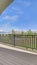 Vertical Balcony overlooking homes lake and mountain under blue sky on a sunny day