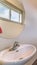 Vertical Bathroom of home with free standing sink round mirror toilet and wooden floor